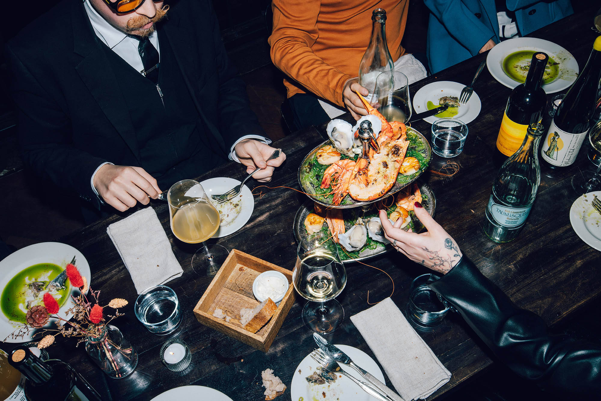 Foto zeigt Abend im KINK Restaurant, Menschen essen und trinken, Fokus auf dem Tisch